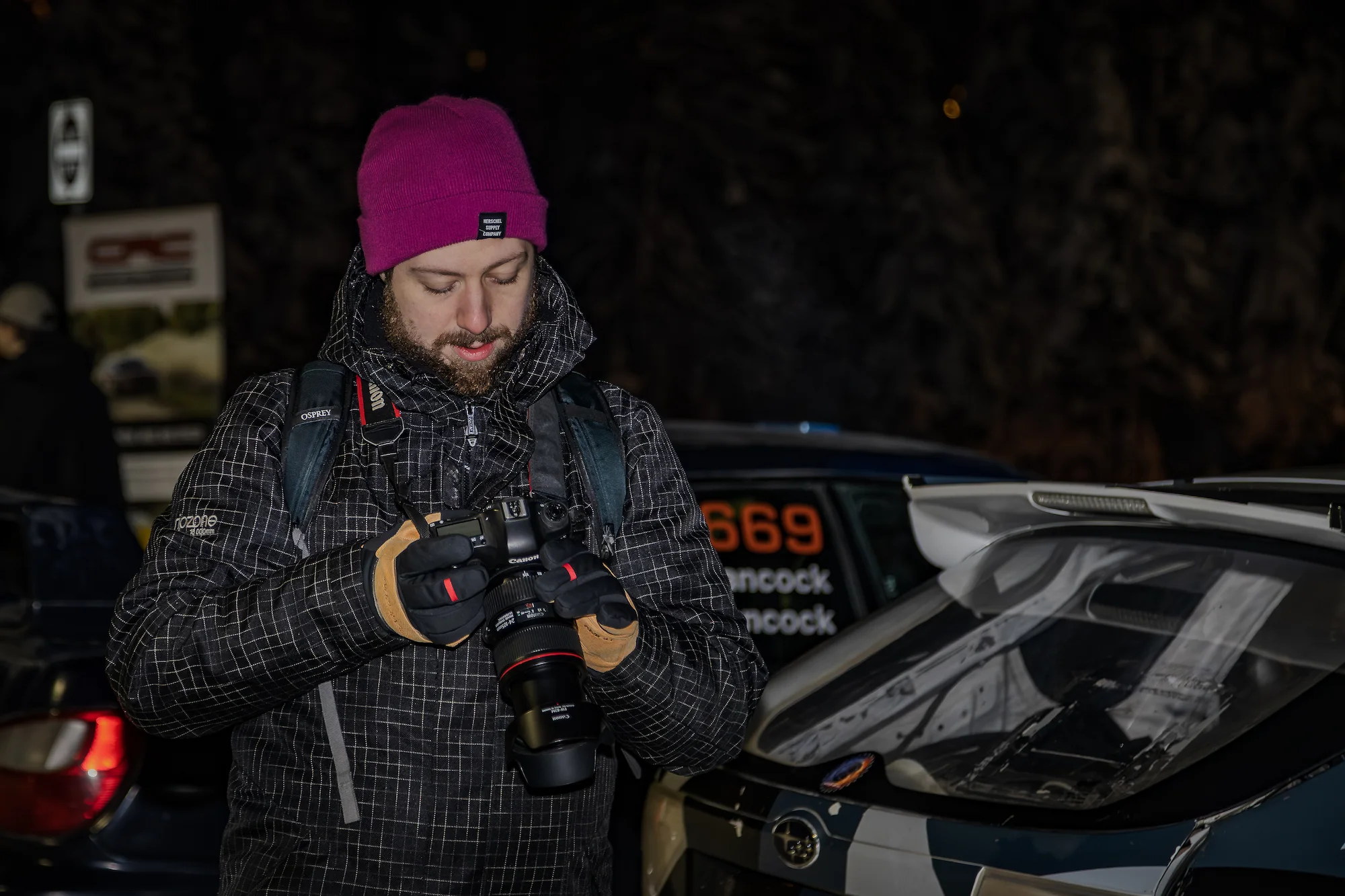 Reed looking at previews on his camera at the Big White Winter Rally in December 2025